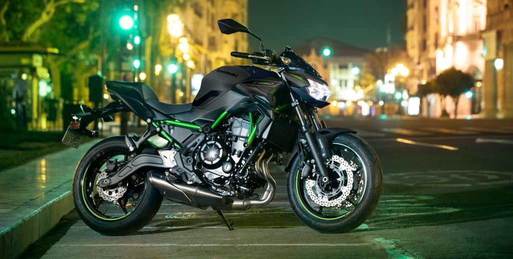 Kawasaki Z650 A2 verte et noire, vue de profil, garée dans une rue de centre-ville.