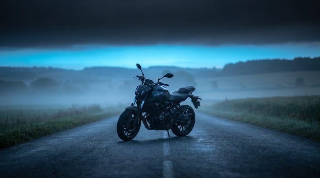 Moto A2 naked roadster stationnée seule route rurale campagne aube brume bleutée premiers mois