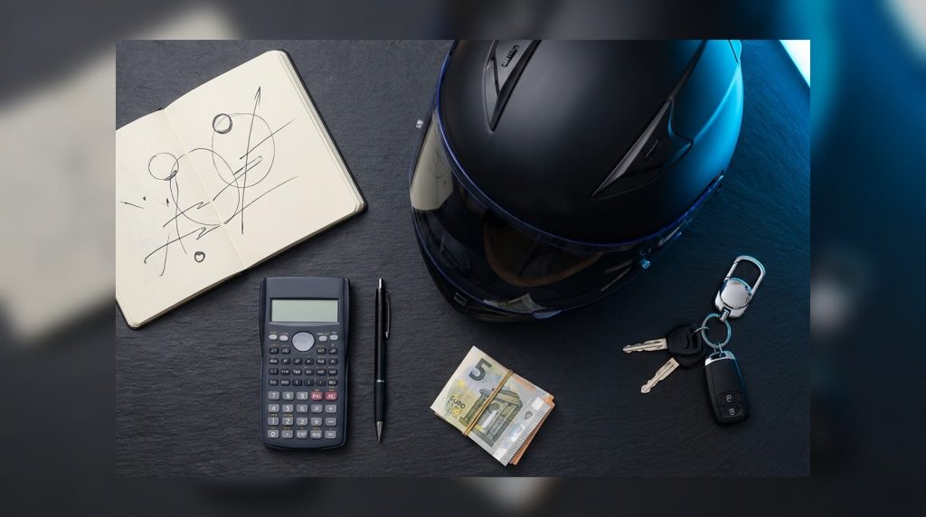 Casque intégral noir mat carnet auto-école clé moto stylo billets euros table ardoise sombre néon bleu